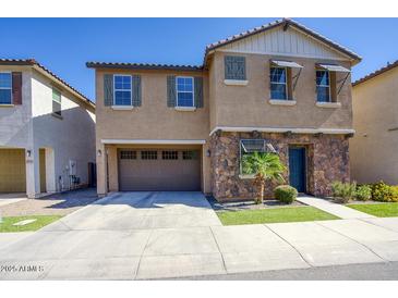 Charming two-story home featuring stone accents, a two-car garage, and a well-manicured front yard at 4242 E Erie St, Gilbert, AZ 85295