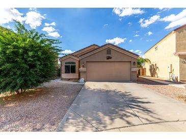 Single story home featuring desert landscaping, large garage, and neutral stucco exterior under blue skies at 42758 W Camino De Janos --, Maricopa, AZ 85138