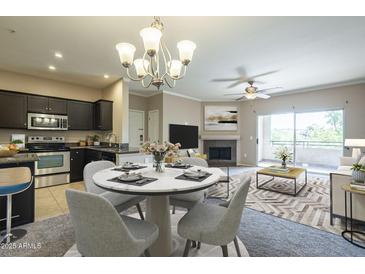 Bright and airy living room with a dining area and fireplace, leading to a balcony with natural light at 5345 E Van Buren St # 305, Phoenix, AZ 85008