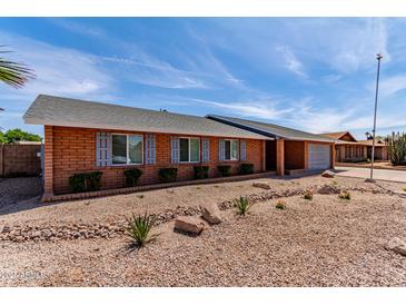 Charming brick home featuring a well-maintained yard and shuttered windows at 5721 W Palo Verde Ave, Glendale, AZ 85302