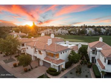 Beautiful townhouse with a red tile roof on a golf course, and a view of mountains at sunset at 7222 E Gainey Ranch Rd # 241, Scottsdale, AZ 85258