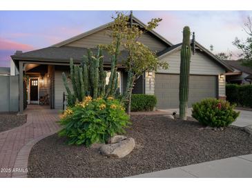 Charming home featuring desert landscaping with mature cacti, shrubs, and a manicured lawn, enhancing its curb appeal at 8037 E Krail St, Scottsdale, AZ 85250