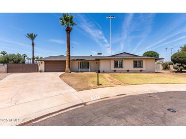 Charming single-story home with a well-maintained lawn, mature palm trees, and a spacious driveway at 8124 N 45Th Ave, Glendale, AZ 85302