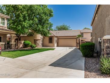 Charming single-story home features stucco siding, a tiled roof, and a spacious driveway leading to an attached garage at 15941 N 171St Ln, Surprise, AZ 85388