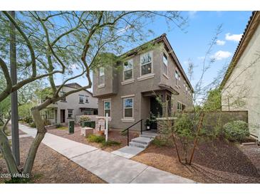 Inviting two-story home featuring desert landscaping, covered porch, and a neatly maintained front yard at 20872 W Thomas Rd, Buckeye, AZ 85396