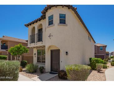 Two-story home featuring a private balcony and stucco exterior with a dark-stained front door at 2947 N Sonoran Hls, Mesa, AZ 85207