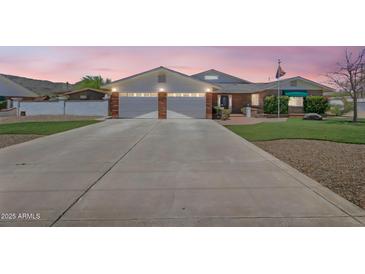Charming single-story home with a brick facade, a spacious driveway, and a well-maintained lawn and front yard at 4304 W Calle Poco --, Laveen, AZ 85339