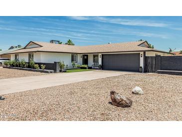 Charming home with a dark gray garage door, rock landscaping, and curb appeal at 11215 N 38Th N Ave, Phoenix, AZ 85029