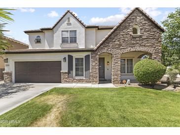 Charming two-story home with a well-maintained lawn and stone archway entrance, creating a welcoming curb appeal at 2144 E Honeysuckle Pl, Chandler, AZ 85286