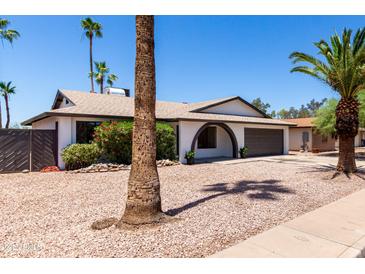 Charming single-story home with a well-manicured desert landscape and arched entryway, creating curb appeal at 2220 S Cottonwood Dr, Tempe, AZ 85282