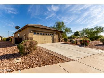 Charming home featuring a well-manicured front yard and a spacious two-car garage with a blue sky backdrop at 22417 W Loma Linda Blvd, Buckeye, AZ 85326