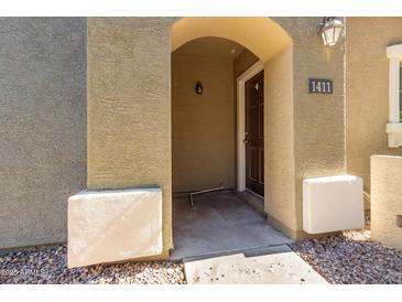 Inviting front entryway with stone facade and covered porch leading to the home's entrance with the address number above the door at 2402 E 5Th St # 1411, Tempe, AZ 85288