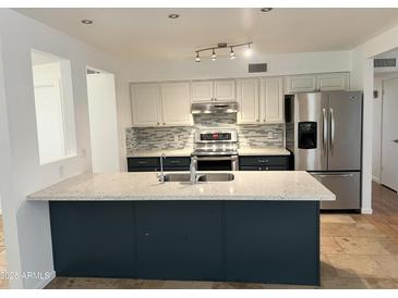 Charming kitchen with granite island, stainless steel appliances, and decorative tile backsplash at 2838 E Contessa St, Mesa, AZ 85213