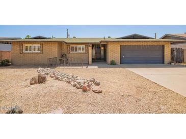 Charming single-story home with a rock lawn, mature landscaping, and a spacious driveway at 3825 W Royal Palm Rd, Phoenix, AZ 85051