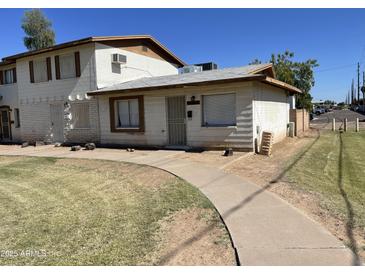 Charming single-Gathering home with a well-maintained lawn and a concrete walkway leading to the entrance at 7109 W Wolf St, Phoenix, AZ 85033