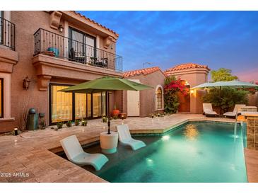Inviting backyard pool with in-pool lounge chairs and lush landscaping at 7530 N Via De La Siesta --, Scottsdale, AZ 85258
