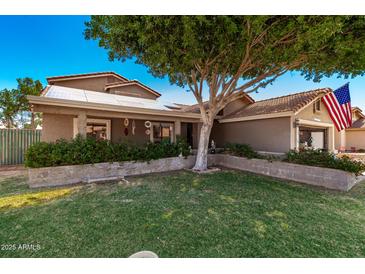 Charming single-story home with a landscaped front yard, solar panels, and an American flag at 937 N Marble St, Gilbert, AZ 85234