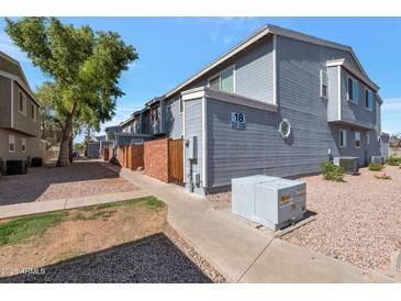 Charming townhome featuring neat landscaping and brick accents near sidewalks under a clear blue sky at 2301 E University Dr # 256, Mesa, AZ 85213