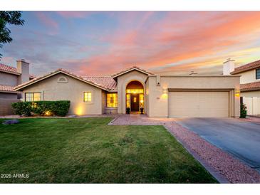 Charming single-Gathering home boasts well-manicured lawn, archway entrance, and attached two car garage at 8875 S Ash Ave, Tempe, AZ 85284
