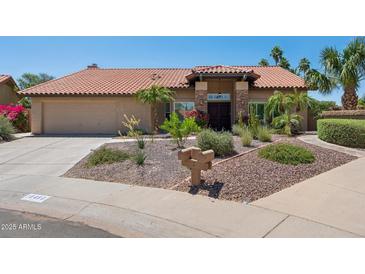 Charming single-story home featuring well-manicured desert landscaping, a red tile roof, and a two-car garage at 10450 E Terra Dr, Scottsdale, AZ 85258