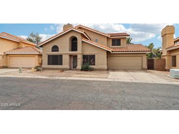Two-story home featuring a tile roof, neutral stucco, and a two-car garage at 1344 N Brittany Ln, Gilbert, AZ 85233