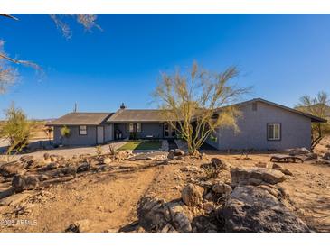 Charming gray single-story home with desert landscaping and clear blue skies at 15612 S Tuthill Rd, Buckeye, AZ 85326