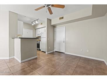Bright living area with tile floors flowing into an efficient kitchen with white cabinets at 1701 E Colter St # 147, Phoenix, AZ 85016