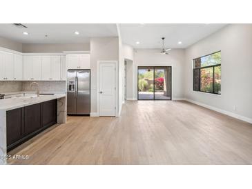 Bright, open-concept living room featuring a modern kitchen with stainless steel appliances and outdoor access at 19550 N Grayhawk Dr # 1144, Scottsdale, AZ 85255
