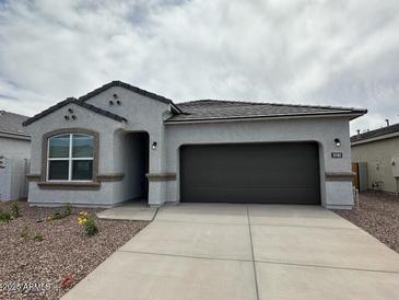 Charming single-story home features a neutral color palette, a covered entryway, and a two-car garage at 25183 N 183Rd Dr, Wittmann, AZ 85361