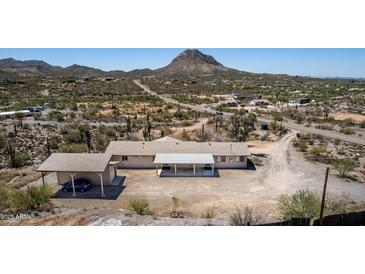 Aerial view of property featuring a car port, desert landscape and mountain views at 48451 N 27Th Ave, New River, AZ 85087
