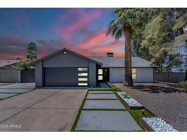 Charming home featuring modern garage door, pathway lighting, and well-manicured landscaping at 5239 E Waltann Ln, Scottsdale, AZ 85254