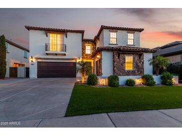 Beautiful two-story home featuring stone accents, a two-car garage, well-manicured lawn, and a balcony over the garage at 861 E Canyon Way, Chandler, AZ 85249