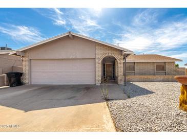 Charming single-story home with a brick facade, desert landscaping, and a two-car garage at 940 S Revere --, Mesa, AZ 85210