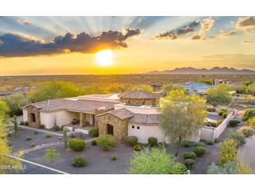Stunning desert home showcasing a grand entrance, beautiful stone accents, and professionally landscaped yard at 6551 E Flat Iron Loop, Gold Canyon, AZ 85118