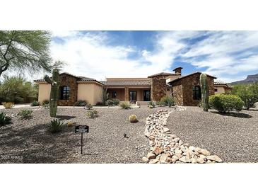 Inviting desert home featuring stonework accents and drought-tolerant landscaping at 6551 E Flat Iron Loop, Gold Canyon, AZ 85118