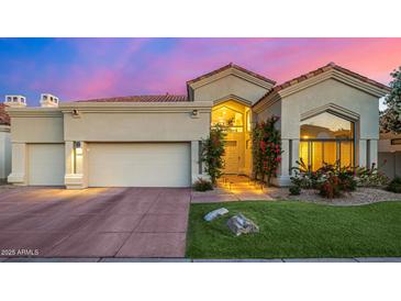 Charming home featuring a beautiful front yard, lush plants, and a two-car garage at 7439 E Beryl Ave, Scottsdale, AZ 85258