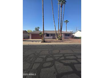 Charming single-story home with mature palm trees and a neatly maintained front yard at 1128 E Malibu E Dr, Tempe, AZ 85282