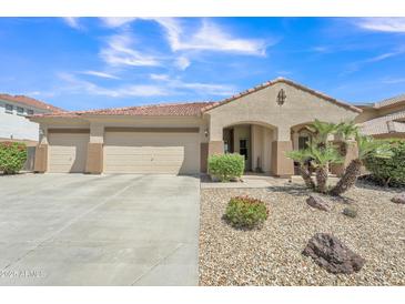 Charming home featuring a spacious three-car garage and low-maintenance desert landscaping at 209 N 237Th Ave, Buckeye, AZ 85396