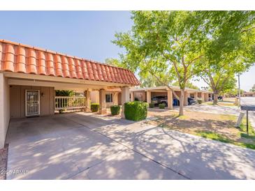 Charming home exterior featuring a spacious carport, vibrant green trees, and a well-maintained lawn at 602 E Colgate Dr, Tempe, AZ 85283