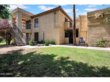 Charming two-story condo with stucco exterior, stairs to upper units, and a well-maintained grassy yard at 8202 N 21St Dr # B101, Phoenix, AZ 85021