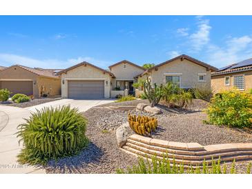 Charming home featuring beautiful desert landscaping, a two-car garage and well-maintained exterior at 20082 N 272Nd Ln, Buckeye, AZ 85396