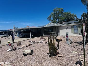 Landscaped front yard with rock, desert plants and covered parking at 2011 N 26Th Cir, Mesa, AZ 85213