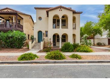Charming two-story home featuring arched entryways, balconies, and a well-manicured front yard at 2854 N Claire Dr, Buckeye, AZ 85396