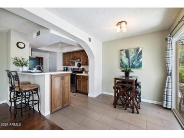 Cozy dining area with counter seating and adjacent kitchen, great for casual meals and entertaining guests at 811 E Eugie Ave, Phoenix, AZ 85022