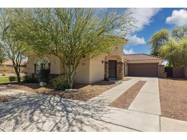 Charming home featuring desert landscaping, a quaint front entrance, and a long driveway leading to a two-car garage at 897 E Cherry Hills Dr, Chandler, AZ 85249