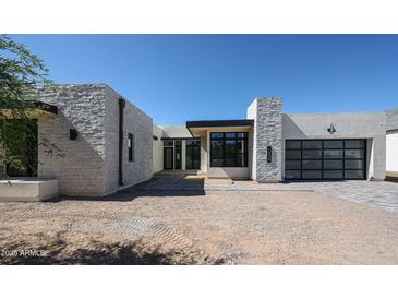 Modern home with stone accents, a glass garage door, and a contemporary design at 1538 W Wagon Wheel Dr, Phoenix, AZ 85021
