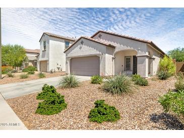 Charming single-story home featuring a low-maintenance desert landscape and a two car garage at 19664 W Woodlands Ave, Buckeye, AZ 85326