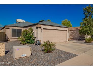 Charming single-story home with a two-car garage, desert landscaping, and clear blue skies at 24648 N 40Th Ln, Glendale, AZ 85310