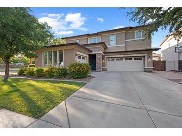 Charming two-story home with a three-car garage, manicured lawn, and vibrant landscaping at 3822 E Amber Ln, Gilbert, AZ 85296