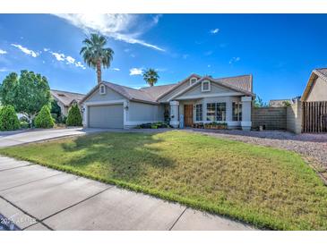 Charming single-story home featuring a well-maintained lawn, desert landscaping and a two car garage at 4050 E Encinas Ave, Gilbert, AZ 85234